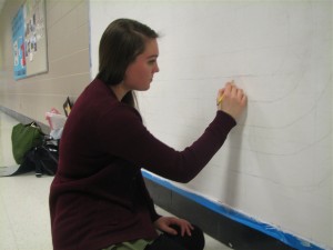 Evelyn Harvey for Headline Evelyn Harvey sketches a new mural across from Mr. Phillip' history classroom as her independent study project. The new painting will be a depiction of American music throughout history.